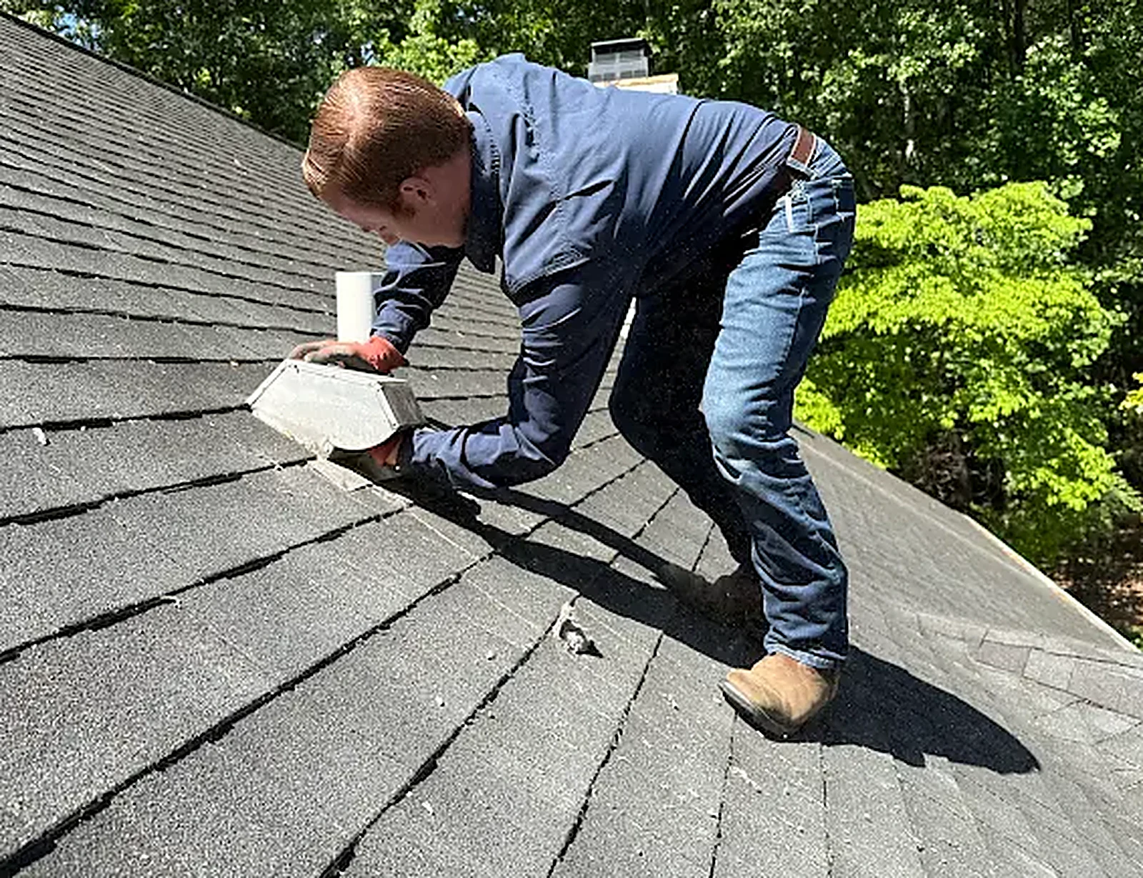 Technician servicing a rooftop dryer vent
